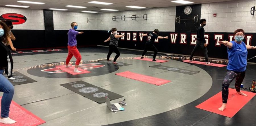 Mrs. Amy Schuiteboer leads a group of advisory students in yoga. Mrs. Amy said she hasn't practiced nearly as much yoga as pre-pandemic, but she wants to get back into it more.